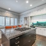 Bright, light-filled kitchen with stainless appliances and island seating for informal meals
